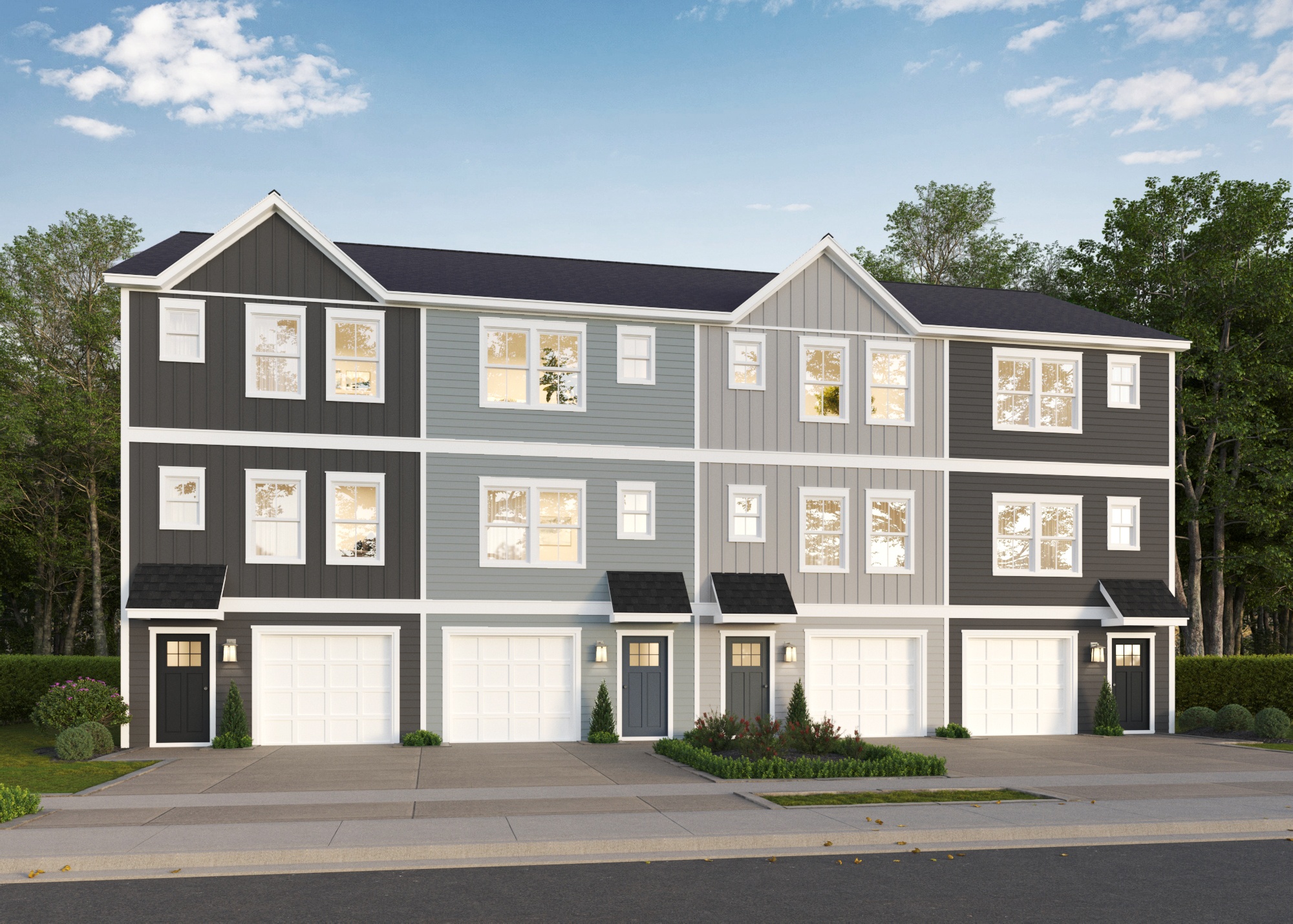 A modern two-story house with a grey and white exterior and black garage doors.